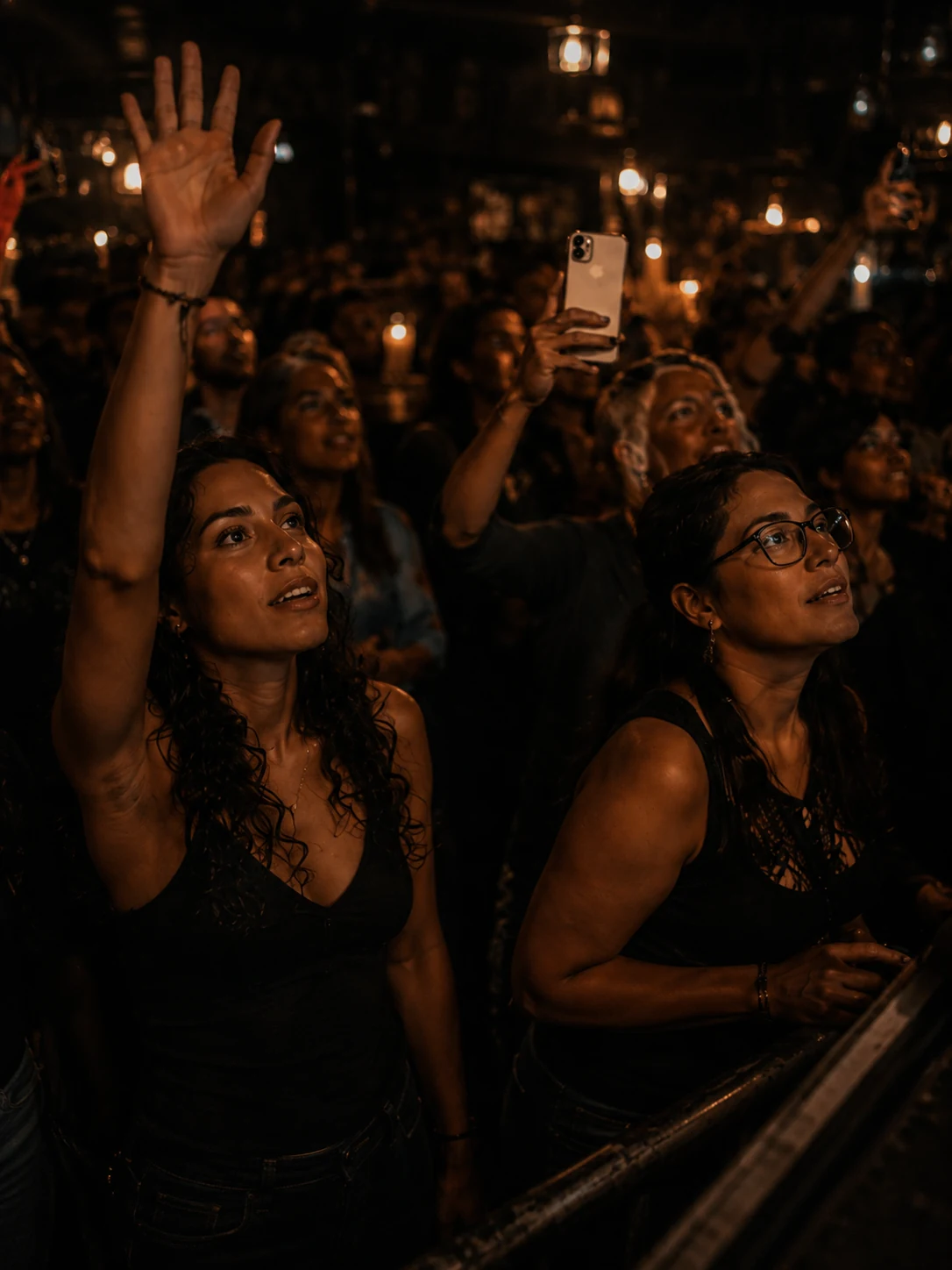 Duas fãs na primeira fila sob luzes quentes